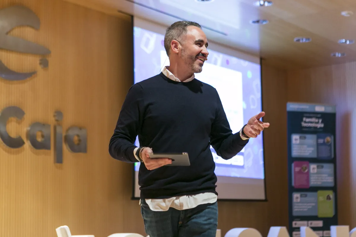 Jorge Mora dando una charla con un micrófono ante una pantalla