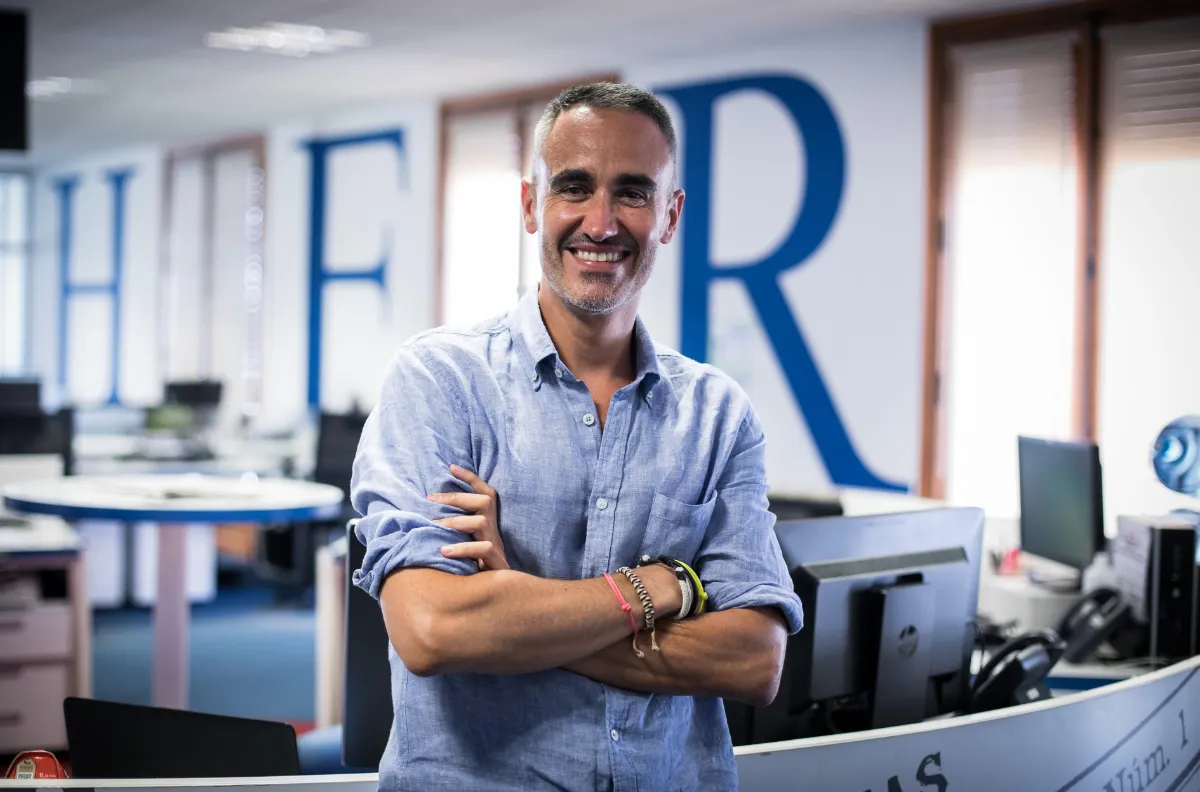 Jorge Mora, de brazos cruzados y sonriendo, en la redacción de Heraldo