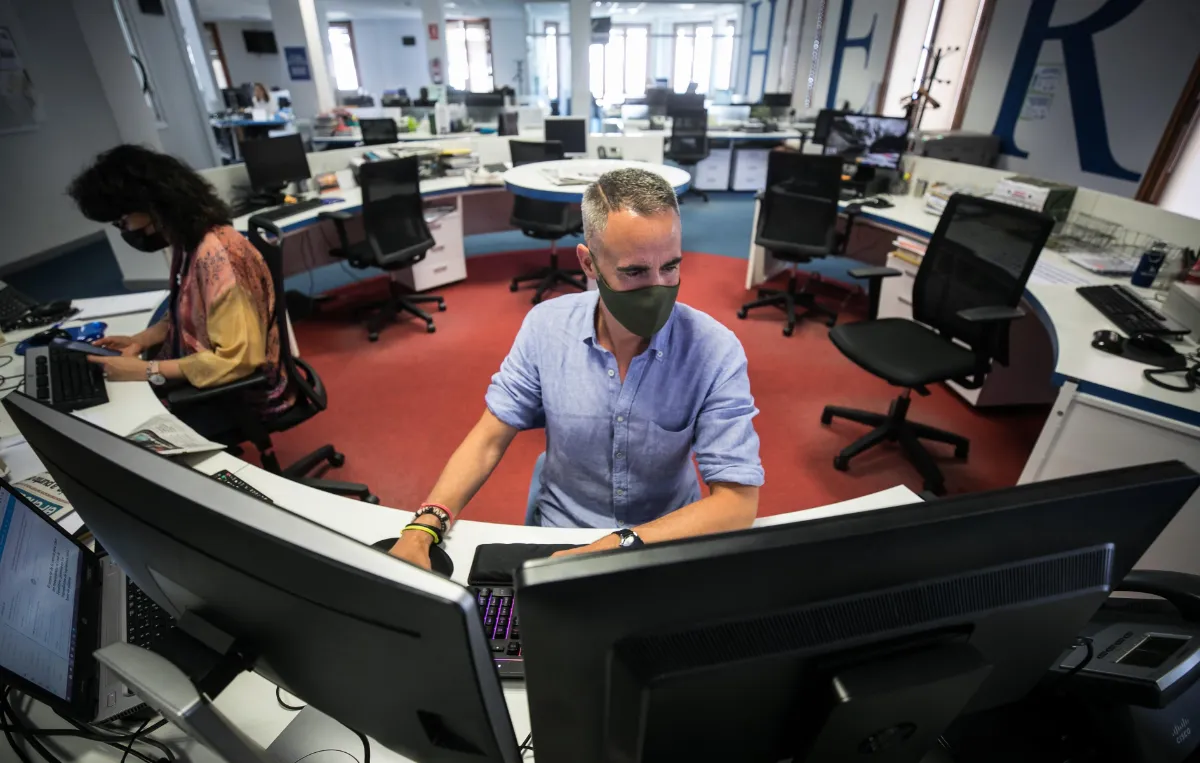 Jorge Mora trabajando en su puesto de la redacción de Heraldo, rodeado de pantallas